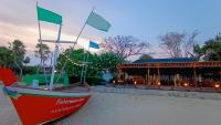 ein Boot am Strand vor einer Bar in der Unterkunft Fisherman's Resort Haad Chao Samran in Haad Chao Samran