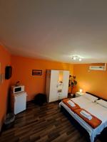 a bedroom with a large bed with an orange wall at Rooms Modrušan in Slunj
