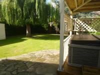 a porch with a grill and a tree in a yard at Garden Suite in Rhuddlan