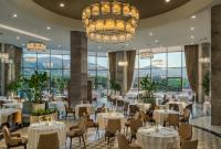 um restaurante com mesas e cadeiras e um lustre em DoubleTree by Hilton Manisa em Manisa