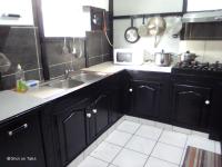 a kitchen with black cabinets and a sink at Meublé de la vallée in Saint-Pierre