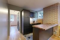 a kitchen with a black refrigerator and a brick wall at LOVE ROOM with jacuzzi and beautiful terrace in Toulouse