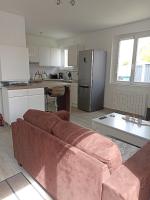 a living room with a couch and a kitchen at Les Mandrines in Saint-Xandre