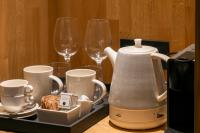 a tea kettle and cups on a tray with wine glasses at Hotel La Pau in Barcelona