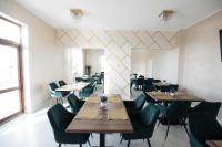 a dining room with wooden tables and green chairs at Hotel Măgura Jina in Jina
