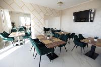 a dining room with wooden tables and green chairs at Hotel Măgura Jina in Jina