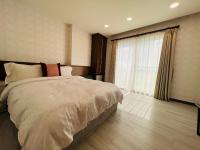 a bedroom with a bed and a large window at Ibizakenting Hotel in Kenting