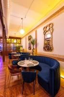 バダホスにあるHotel Las Tres Campanasの青いソファ、テーブル、椅子が備わるレストラン