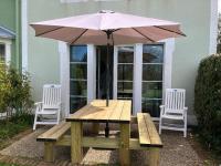 a picnic table with an umbrella and two chairs at Belle Dune in Fort-Mahon-Plage