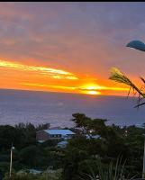 a sunset over the ocean with a house at studio Les Alysées in Saint-Pierre