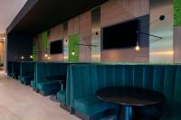 Un bar con asientos azules y un televisor de pantalla plana. en Embassy Suites By Hilton Asheville Downtown, en Asheville