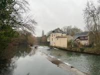 a river with houses and buildings next to a river with trees at Le Moulin du Clain - Jolie maison à Poitiers in Poitiers