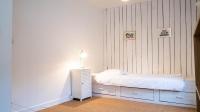 a white bedroom with a bed with a lamp on it at Le Moulin du Clain - Jolie maison à Poitiers in Poitiers