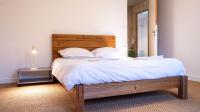 a bedroom with a bed with a wooden headboard and a mirror at Le Moulin du Clain - Jolie maison à Poitiers in Poitiers