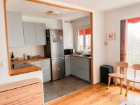 a kitchen with a stainless steel refrigerator and a table at Appartement tout confort avec vue in Saint-Denis