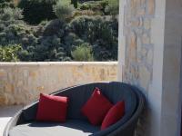 a wicker couch with four red pillows on a patio at Magnificent Villa in Saint Ambroix with Private Pool in Saint-Ambroix
