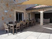 a patio with a table and chairs and a stone wall at Magnificent Villa in Saint Ambroix with Private Pool in Saint-Ambroix