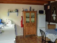 a kitchen with a cabinet and a table and a refrigerator at Snug cottage in Saint Eutrope De Born with pool in Saint-Eutrope-de-Born