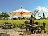 a table and chairs under an umbrella in a field at Snug cottage in Saint Eutrope De Born with pool in Saint-Eutrope-de-Born