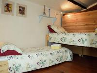 a bedroom with two beds and a wooden wall at Snug cottage in Saint Eutrope De Born with pool in Saint-Eutrope-de-Born