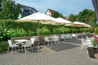 a group of tables and chairs with umbrellas at Der Charlottenhof in Ahrenshoop