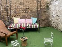 a patio with a swing and a chair and a bench at MAISON PLEIN SUD SUR LES TOITS au 2 terrasses in Montagnac