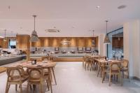 um restaurante com mesas e cadeiras de madeira e uma cozinha em SKYLA Studios & Suites - Kondapur em Hyderabad