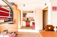 a small kitchen with white cabinets and a red refrigerator at Résidence Les Temples du Soleil - maeva Home - 2 Pièces 5 Personnes Sélect 52 in Val Thorens