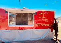 una persona parada al lado de un camión de comida rojo en Cripple Creek Hospitality House, en Cripple Creek