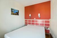a bedroom with a white bed and orange walls at Résidence le Village de Cap Esterel - maeva Home - Appartement 3 pièces 6 p 66 in Saint-Raphaël