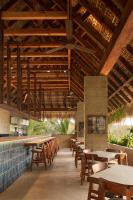 een restaurant met houten plafonds en tafels en stoelen bij Ennea Hotel - Adults Only in Puerto Escondido