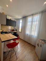 a kitchen with a counter and two red chairs at Charmant studio alle porte di Monte-Carlo in Beausoleil