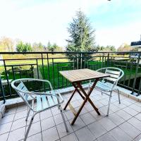 a wooden table and two chairs on a balcony at Beautiful apartment * parking* Disneyland 10 min in Montévrain
