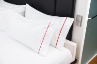 a white bed with white sheets and red stripes at citizenM New York Times Square in New York
