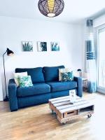a living room with a blue couch and a coffee table at Beautiful apartment * parking* Disneyland 10 min in Montévrain