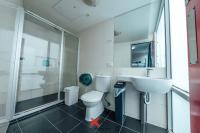 a bathroom with a toilet and a sink and a shower at Nomads St Kilda in Melbourne