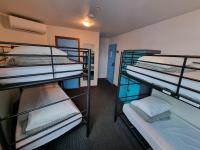 a room with three bunk beds in it at Nomads St Kilda in Melbourne