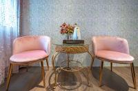 two pink chairs sitting next to a table with a lamp at Sunny Homestay in Ji&#39;an
