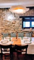a dining room with a table with chairs and a stone wall at Posada La Dalia in Castillo-Pedroso