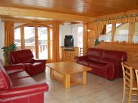 a living room with red leather furniture and a table at Spacious holiday home near center of Champagny in Le Villard