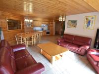 a living room with couches and a table and a kitchen at Spacious holiday home near center of Champagny in Le Villard