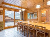 a dining room with a large wooden table and chairs at Spacious holiday home near center of Champagny in Le Villard