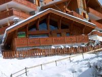 a large building with a balcony in the snow at Spacious holiday home near center of Champagny in Le Villard