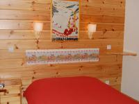 a bedroom with a red bed and a poster on the wall at Spacious holiday home near center of Champagny in Le Villard