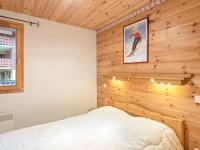 a bedroom with a bed in a wooden wall at Spacious holiday home near center of Champagny in Le Villard