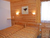 a bedroom with a bed and a wooden wall at Spacious holiday home near center of Champagny in Le Villard