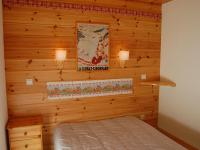 a bedroom with a wooden wall with a bed and lights at Spacious holiday home near center of Champagny in Le Villard