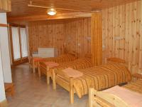 a room with three beds and chairs and wooden walls at Spacious holiday home near center of Champagny in Le Villard