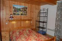 a bedroom with a bed and a wooden wall at Spacious holiday home near center of Champagny in Le Villard