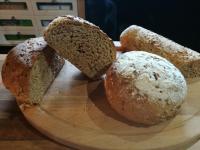 tre pagnotte di pane su un piatto di legno di Millésime a Perville